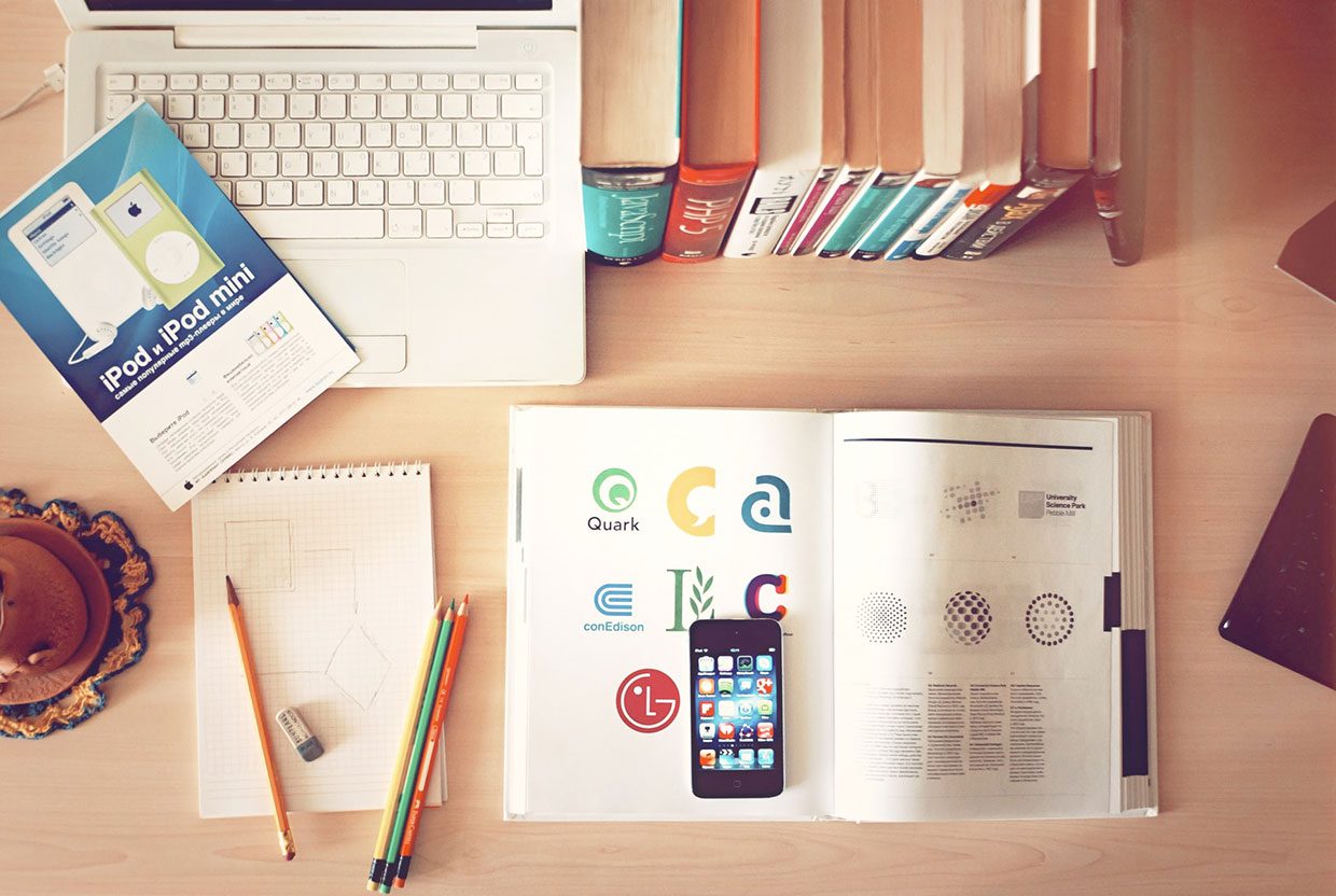 pencils and phone on top of books